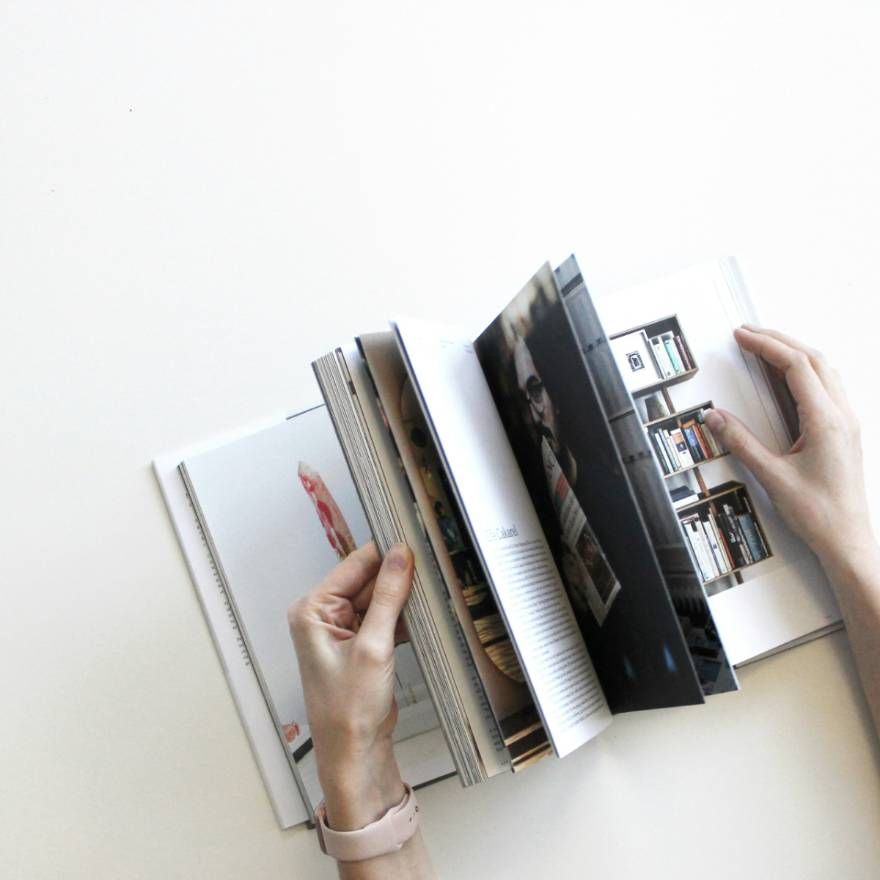 Hands flipping through a printed photo book